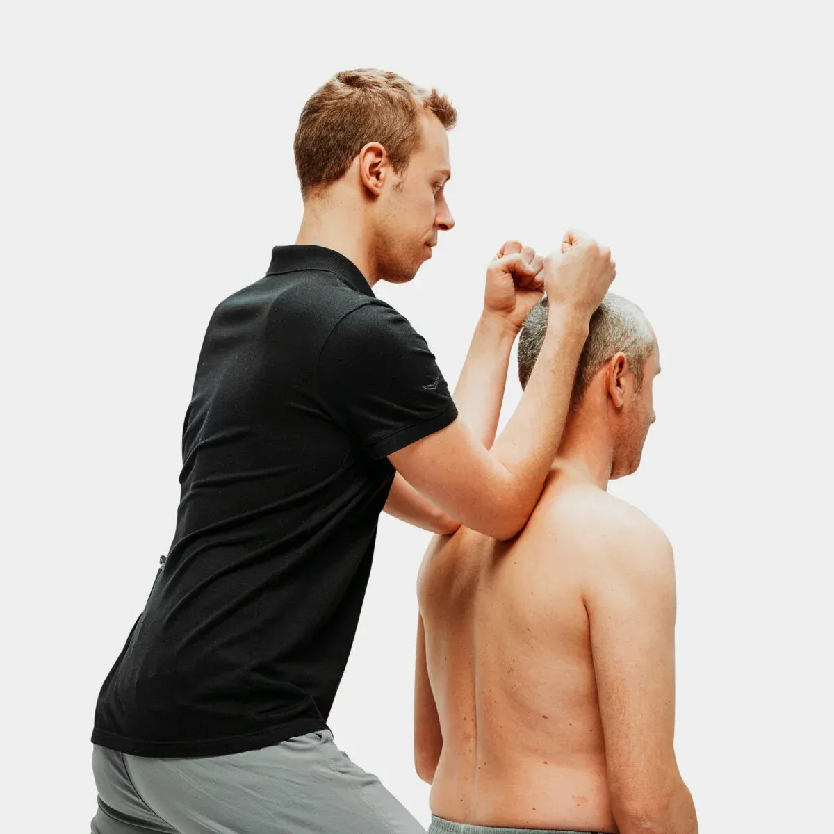 Physiotherapeut behandelt einen Patienten mit manueller Therapie an Nacken und Schulter – Physiotherapie in Karlsruhe